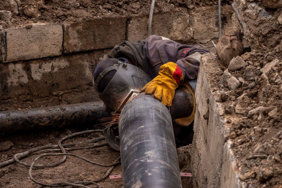 Close-up view of a drainage engineer inspecting a drain pipe in a residential garden